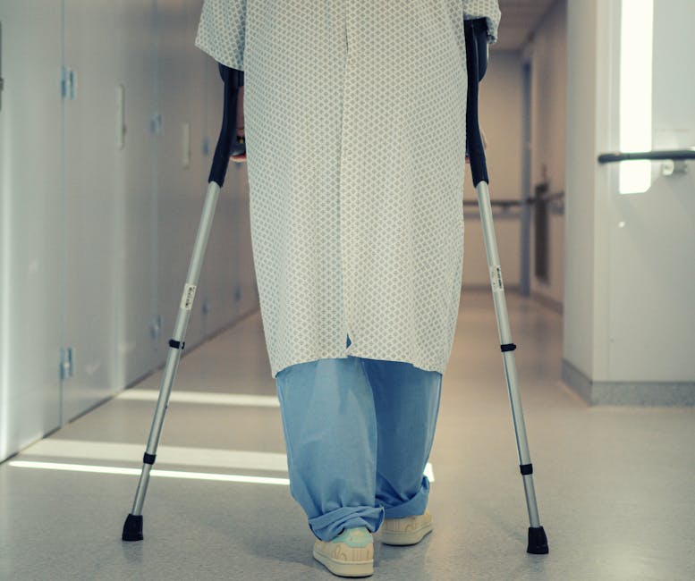 What to Expect in the First 6 Weeks After Hip Replacement Senior patient using crutches to walk down a hospital corridor during hip replacement recovery